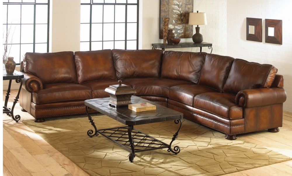 Traditional Distressed Brown Leather Sofa In Curvy Sectional Shape With Dark Wrought Iron Tables And Shelves 
